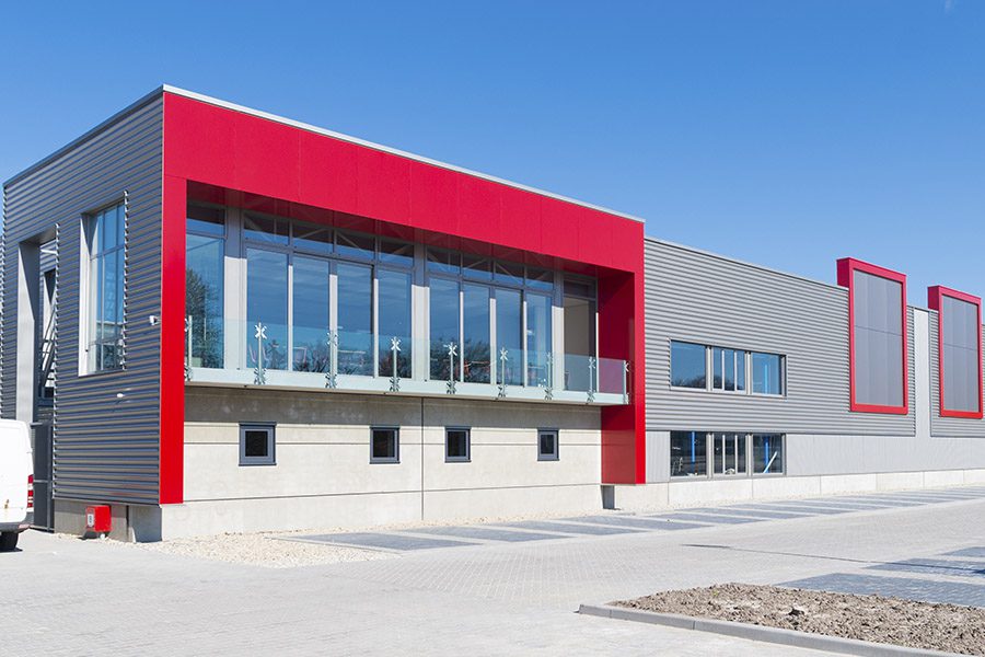 Specialized Business Insurance - Angled View of a Concrete Commercial Building With Red Finishes on it During a Sunny Day